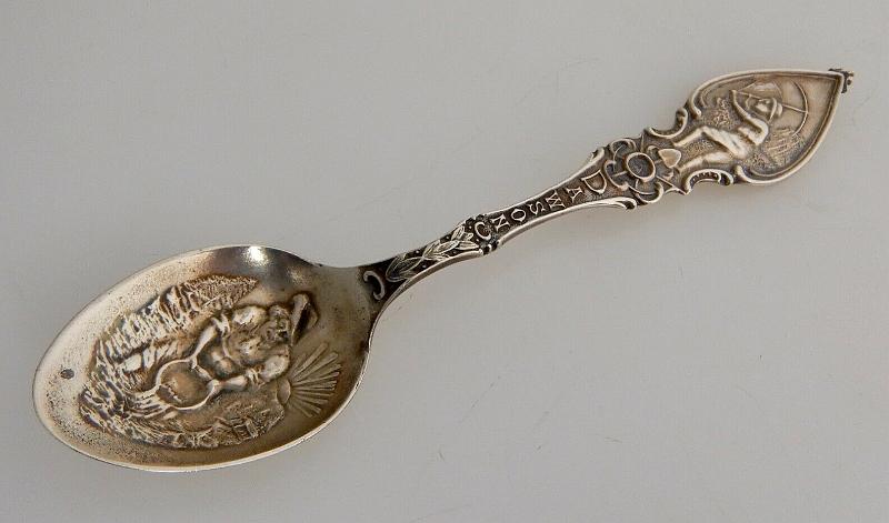 Souvenir Mining Spoon Dawson City Yukon Canada.jpg - SOUVENIR MINING SPOON DAWSON CITY YUKON - Sterling silver demitasse spoon, 4 3/8 in. long, embossed miner figure panning for gold in bowl, handle marked DAWSON with a miner holding a pick at top, ca.1900, reverse with Sterling marking and maker’s mark of P. W. Ellis & Co. Toronto Canada (1877 -1928) later absorbed by Henry Birks & Sons of  Montreal in 1928, weight 12 gms. [When news first broke of gold being discovered in the Yukon, what became immortalized as the Klondike Gold Rush of 1896-99 kick started a mass influx of prospectors into the small northern town of Dawson City.  Founded in 1897, and fittingly named after noted Canadian geologist George M. Dawson, Dawson City became the heart of the Klondike Gold Rush and the capital of the Yukon, the center of activity for the thousands upon thousands of prospectors who flooded in each year. The hope of striking it rich was more than enough to stir the imaginations of an estimated 100,000 men and women who risked life and limb to make their fortune in the northern capital. Built up seemingly overnight, Dawson City was little more than a remote trade outpost at the dawn of the Gold Rush, with the first settlers forced to sleep in tents and under their own wagons. The town that became Dawson City grew exponentially over the next few years.  Constructed mainly out of wood, and where extra expense could be spared, capped in pressed tin, the town included false fronts and wooden sidewalks.  Before long, Dawson City had grown into a proper town, complete with hotels, saloons, banks, and more than one theatre. Faced with what by any route, either by land or sea, was sure to be a journey fraught with peril, thousands of fortune seekers made their way to the Klondike via the infamous Chilkoot Pass, an unforgiving mountain stretch that soon became synonymous with the Klondike Gold Rush. Often carrying more than 100 pounds of supplies on their backs, and outfitted in the extraordinarily inadequate winter clothes and hiking gear of the day, travelers were often forced back by the cold, or simply died along the way. The vast majority of those who made it to Dawson City would leave as ruined souls with not a penny, or nugget, to their name. By 1899, the Klondike Gold Rush was all but over, and the last stragglers and determined hopefuls abandoned Dawson City over the course of the next few years. The peak population of 40,000 in 1898 plummeted to well below 5,000 by 1902. Into the first half of the 20th century, Dawson's fortunes continued to slide. In 1953, Yukon’s official capital was moved to Whitehorse.]